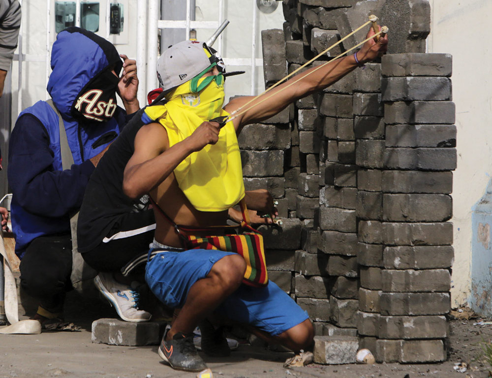  An anti-government demonstrator uses a slingshot during clashes with riot police at a barricade in the town of Masaya.  (Photo: INTI OCON/AFP/Getty Images)  