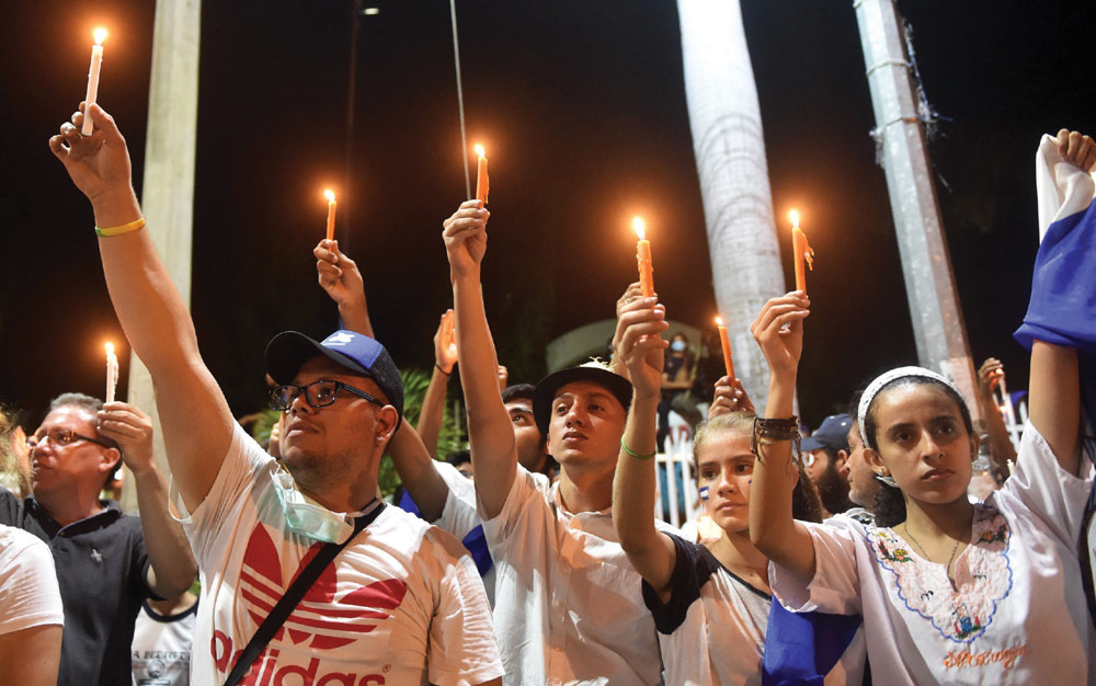  Students light candles during vigil after taking part in the “Walk for Peace and Dialogue” in Managua, where many demand Nicaraguan President Daniel Ortega and his wife Vice-President Rosario Murillo step down. Ortega has been under pressure to step down after announcing, then walking back a contentious pension reform plan that triggered days of protests and violence.  (Photo: RODRIGO ARANGUA/AFP/Getty Images)  